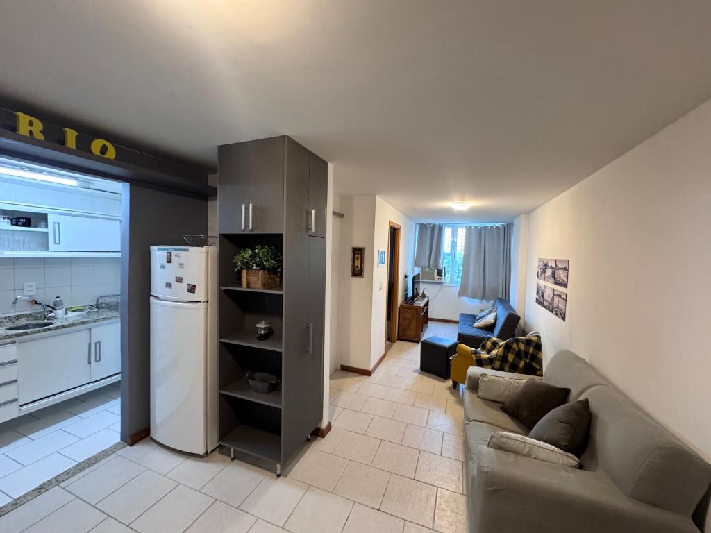 a living room with a couch and a kitchen at Lapa reformado melhor localização in Rio de Janeiro