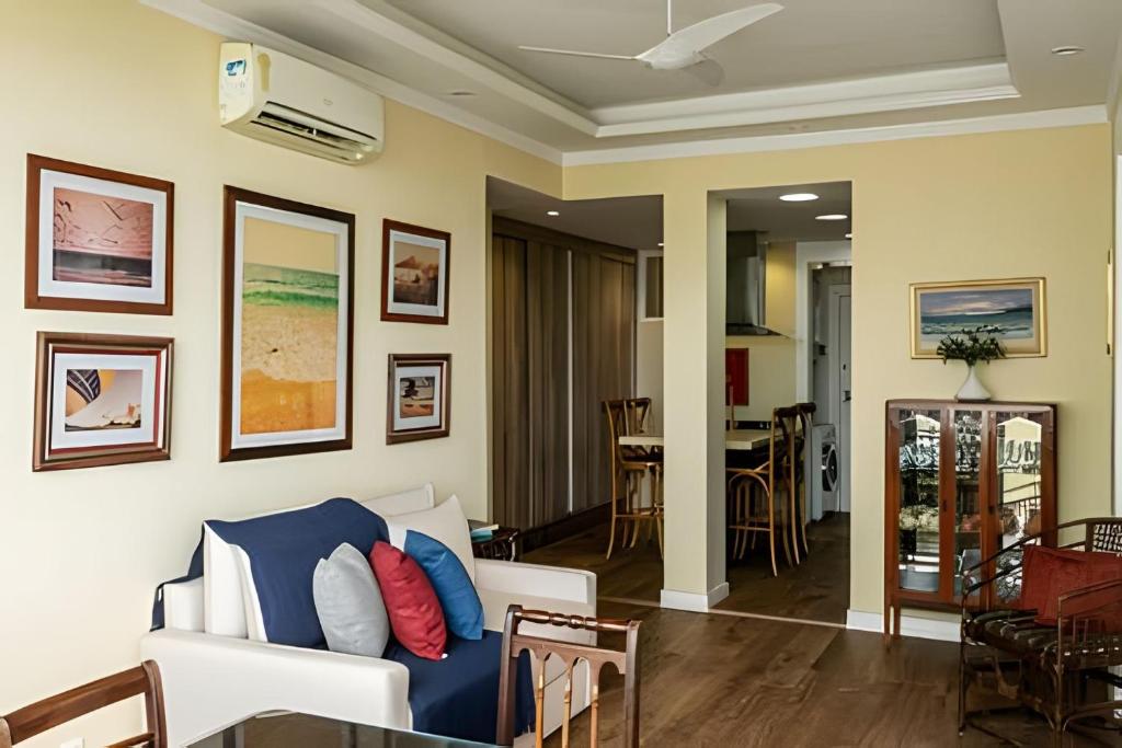 uma sala de estar com um sofá e uma sala de jantar em Copacabana ampla vista mar no Rio de Janeiro