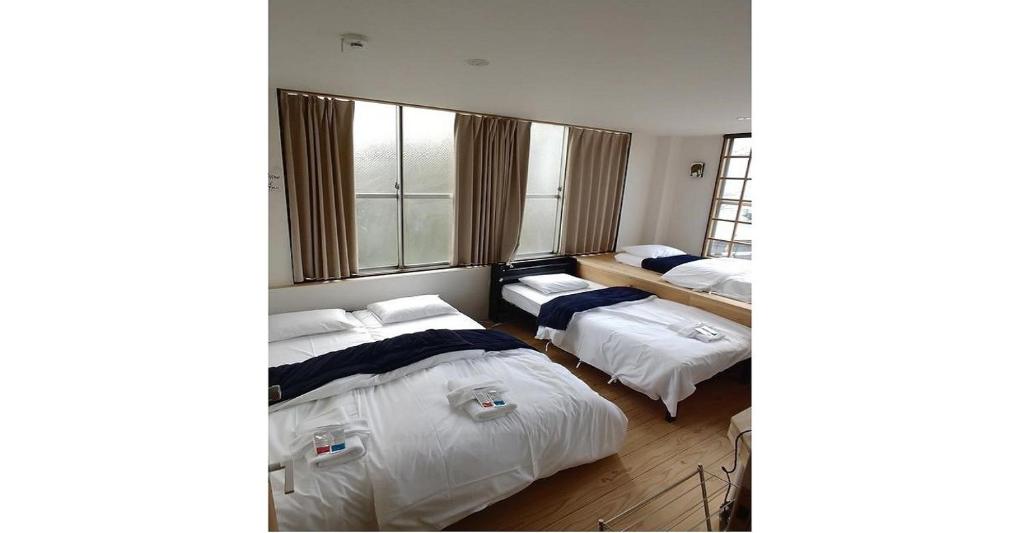 名古屋市にあるNagoya Hostel The Three Smiles / Vacation STAY 13462のベッド2台と窓のある寝室