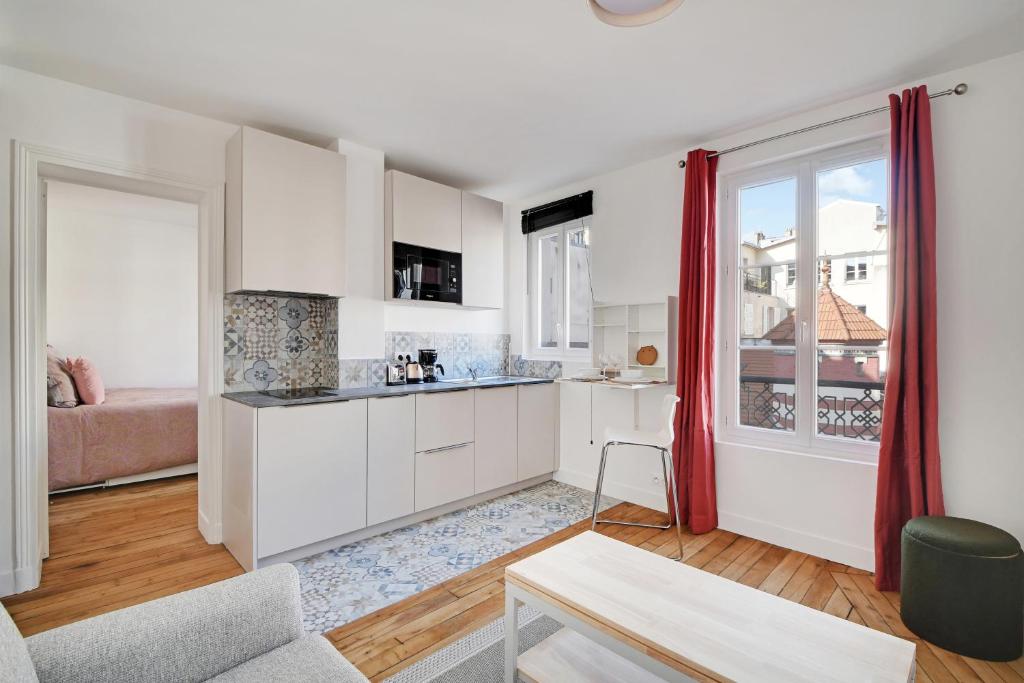 une cuisine avec des armoires blanches et un salon dans l'établissement Pantheon - Quartier Latin, à Paris