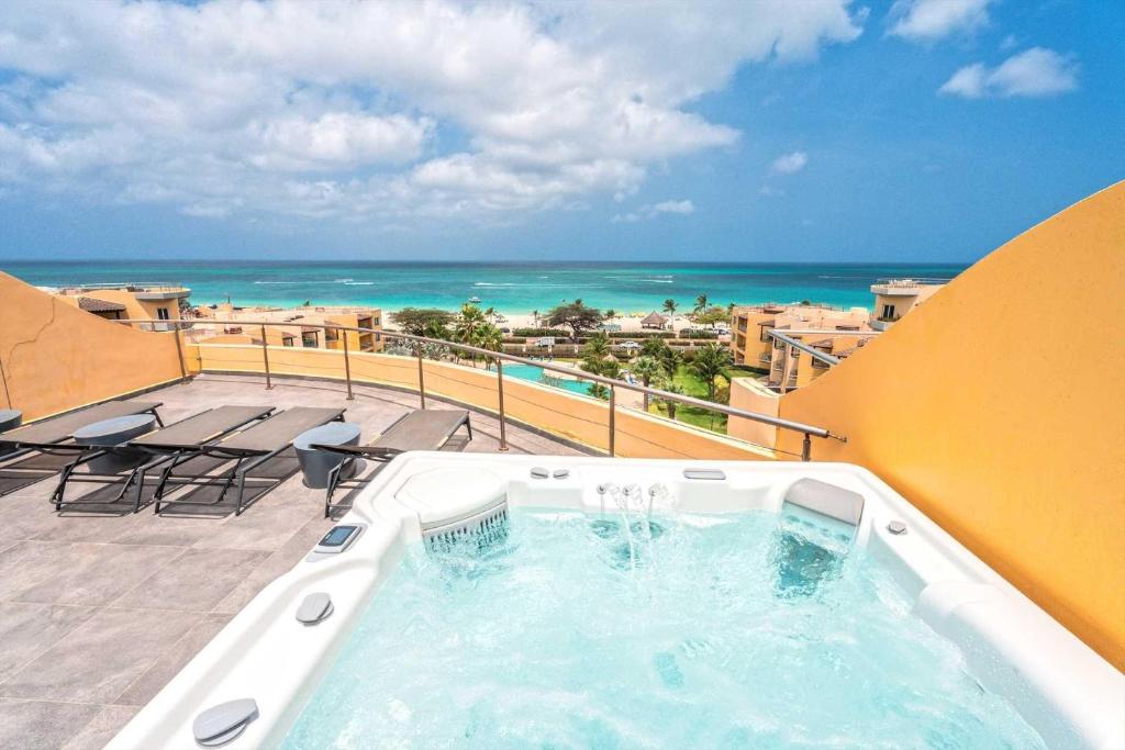 d'un bain à remous sur un balcon avec vue sur l'océan. dans l'établissement Beachfront - Panoramic View 4BR Penthouse - PH4, à Palm-Eagle Beach