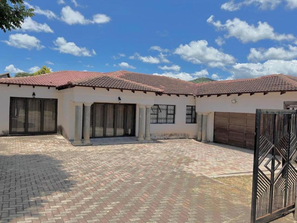 a large white house with a red roof at The Ripanga Nest in Nelspruit