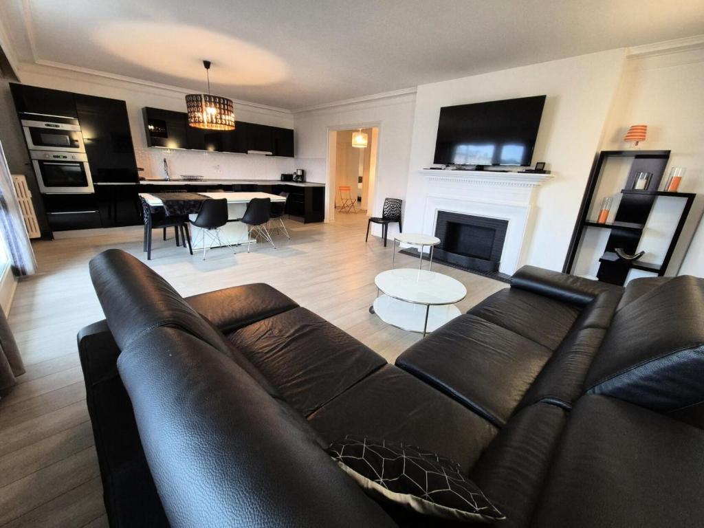 un salon avec un canapé en cuir et une cheminée dans l'établissement Résidence Le Constellation - Logement spacieux au coeur ville d'Aix les Bains ! MAE-6394, à Aix-les-Bains
