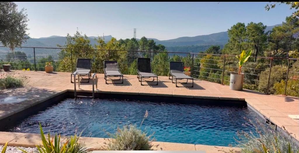 un groupe de chaises assises à côté d'une piscine dans l'établissement Villa de Montchamp, à Chambonas
