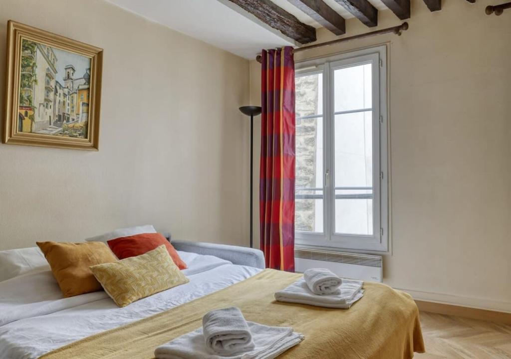 une chambre avec un lit avec des serviettes dessus dans l'établissement Typical & Charming flat near St Germain - Mid-term, à Paris