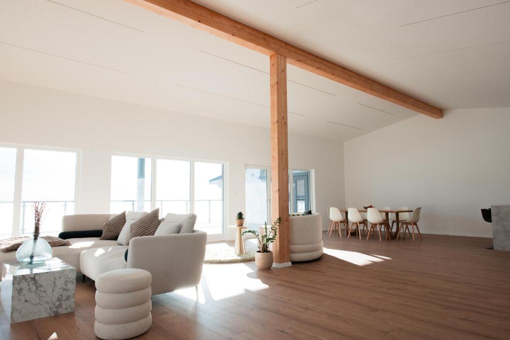 a living room with white furniture and a table at Hohenzollern Wellness Loft mit Panorama Sauna in Burladingen
