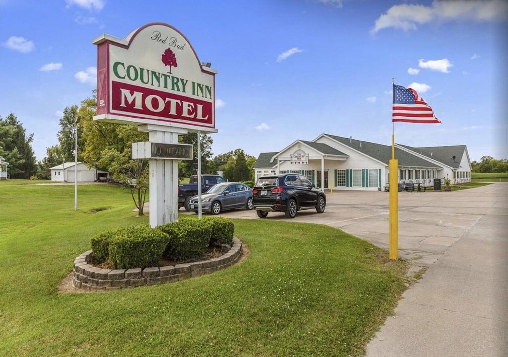 a sign for a motel with an american flag at Red Bud Country Inn in Red Bud
