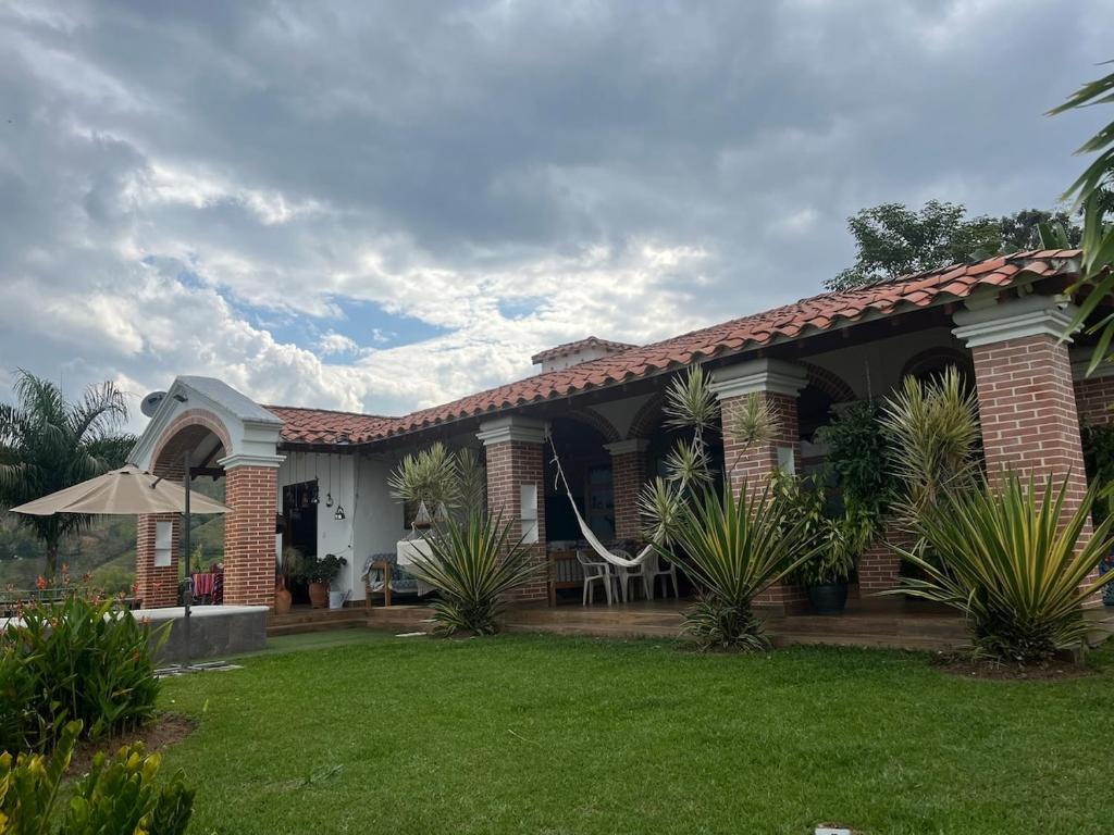 a house with a lawn in front of it at Casa colonial hermosa divisa a 1 45 h de Medellin in Venecia