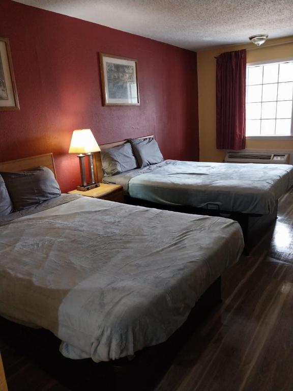 two beds in a hotel room with red walls at 2 Double Beds Hotel Room 222 in Jackson