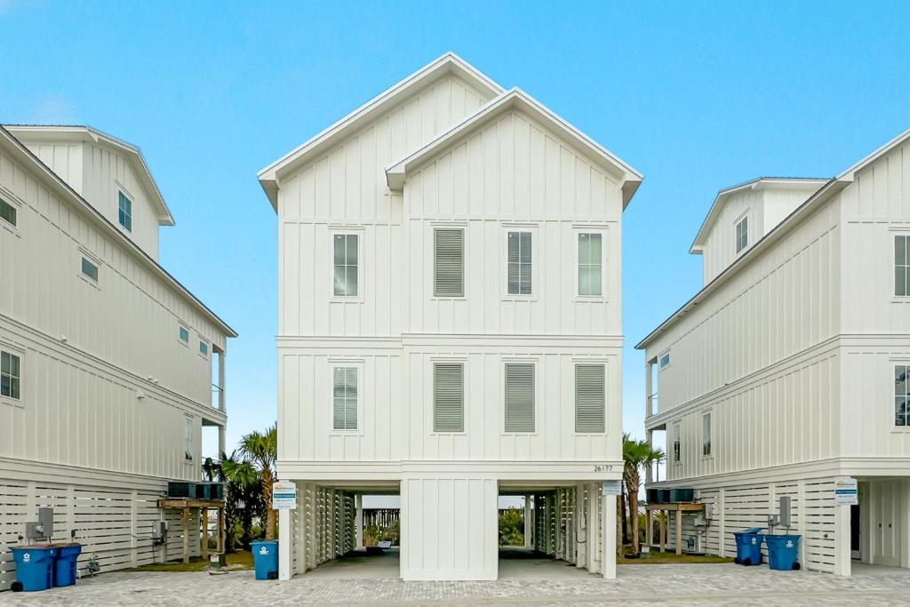 una casa blanca entre dos edificios en Feels Like Home at The Osprey, en Orange Beach
