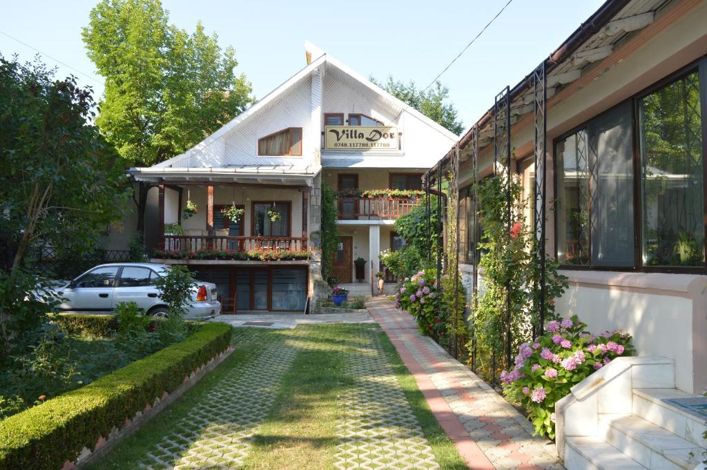 a house with a garden in front of it at Vila Villador in Piatra Neamţ