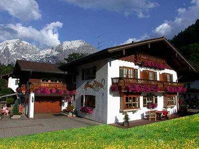 a white house with flowers in front of it at Gästehaus Alexandra in Ramsau