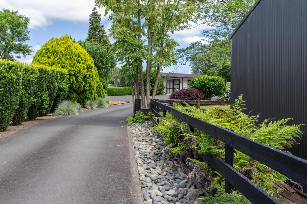 a driveway with a fence next to a house at 73 Milton Accommodation in Cambridge
