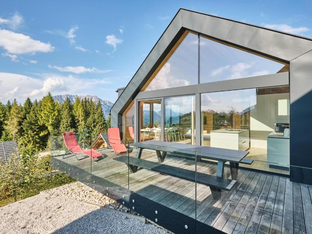 a house with glass walls and a picnic table on a deck at Lakan Lodge in Michaelerberg