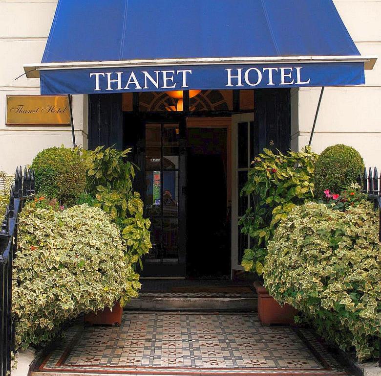 a small garden with a blue door and a purple umbrella at Thanet Hotel in London