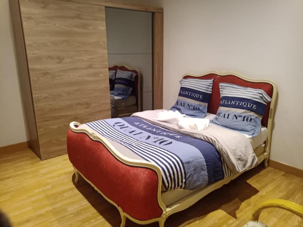 Un dormitorio con una cama con almohadas azules y blancas. en Résidence les jardins secrets, en Romilly-sur-Seine