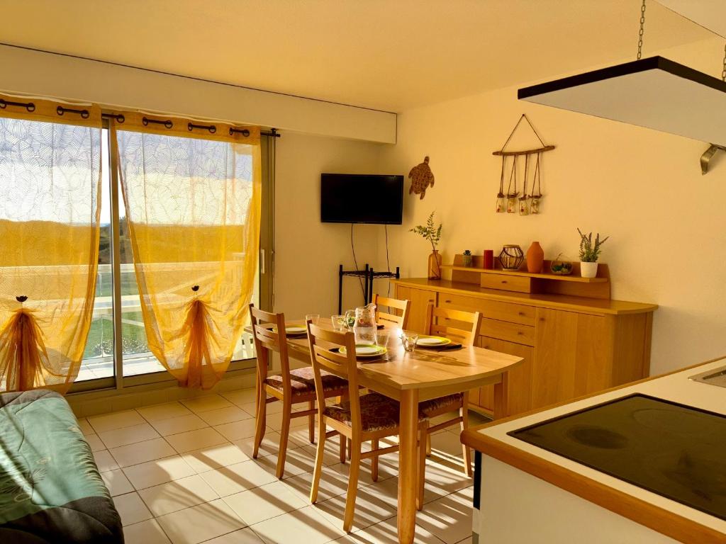 une cuisine avec une table et des chaises dans une cuisine dans l'établissement Appartement lumineux proche golf et plage à Saint Jean de Monts - FR-1-323-465, à Saint-Jean-de-Monts