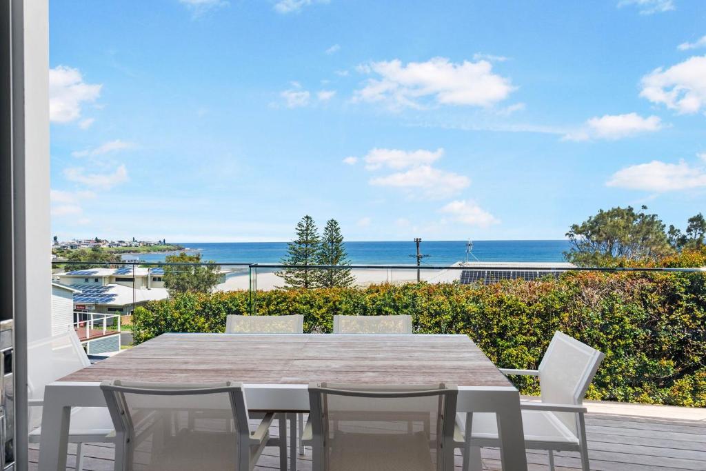 a table and chairs on a balcony with a view of the ocean at Riverleigh, Gerroa in Gerroa