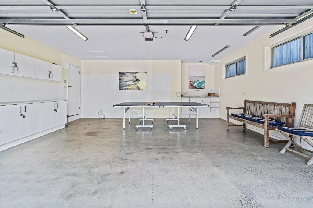 an empty room with a table and benches in it at Riverleigh, Gerroa in Gerroa
