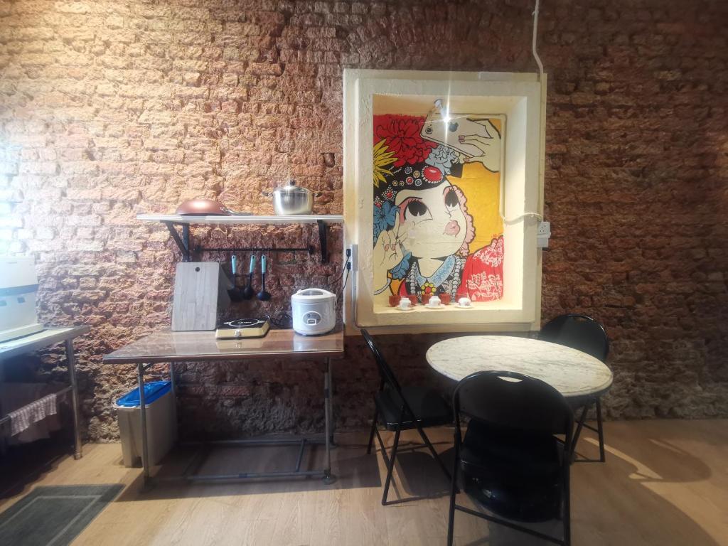 a table and chairs in a room with a brick wall at MacGem Heritage House at Georgetown Penang in George Town