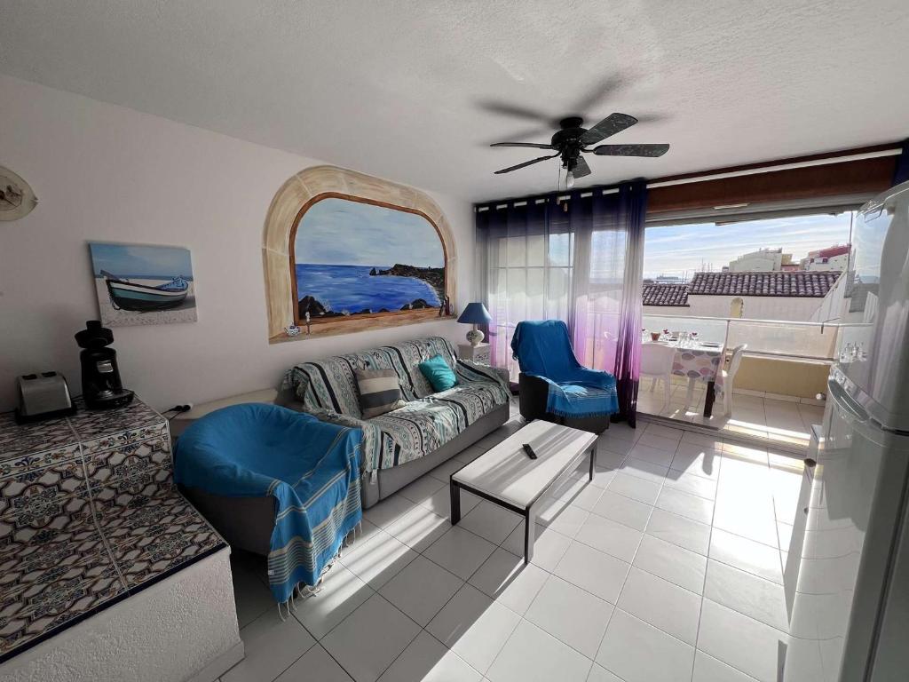 un salon avec un canapé et un ventilateur de plafond dans l'établissement Appartement T2 avec Terrasse et Parking, à 50m de la Plage - FR-1-702-70, au Cap d'Agde