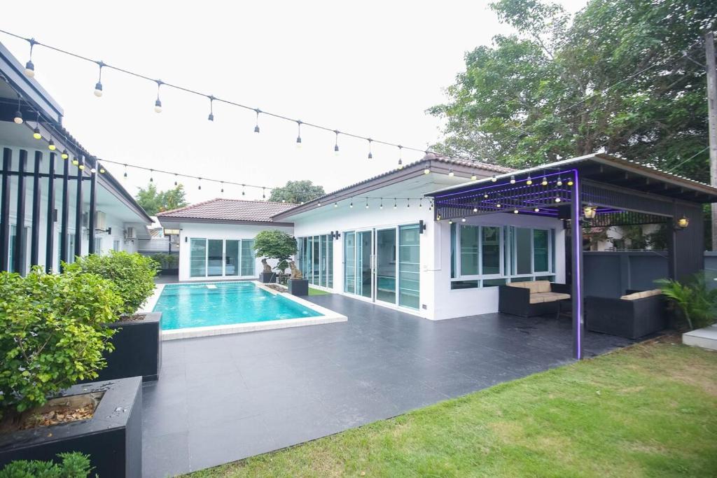a house with a swimming pool in a yard at Pool Villa near Chiang Mai city with WiFi in Saraphi