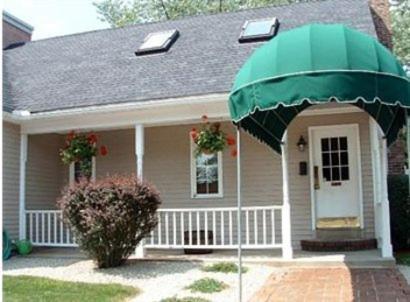 een klein huis met een groene paraplu ervoor bij Park View Inn in Salem