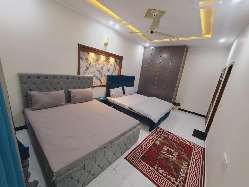 a small bedroom with two beds and a rug at Kashees Lodges in Islamabad