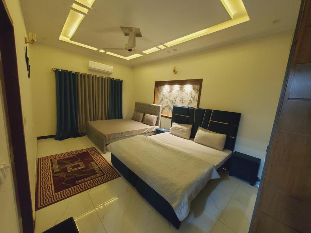 a bedroom with two beds and a window at Kashees Lodges in Islamabad