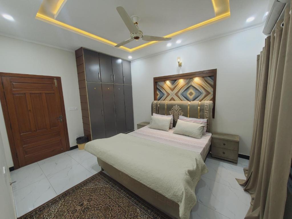 a bedroom with a bed and a ceiling at Kashees Lodges in Islamabad