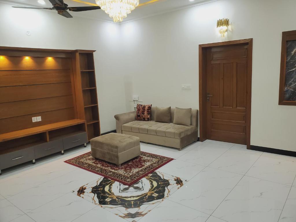 a living room with a couch and a door at Kashees Lodges in Islamabad