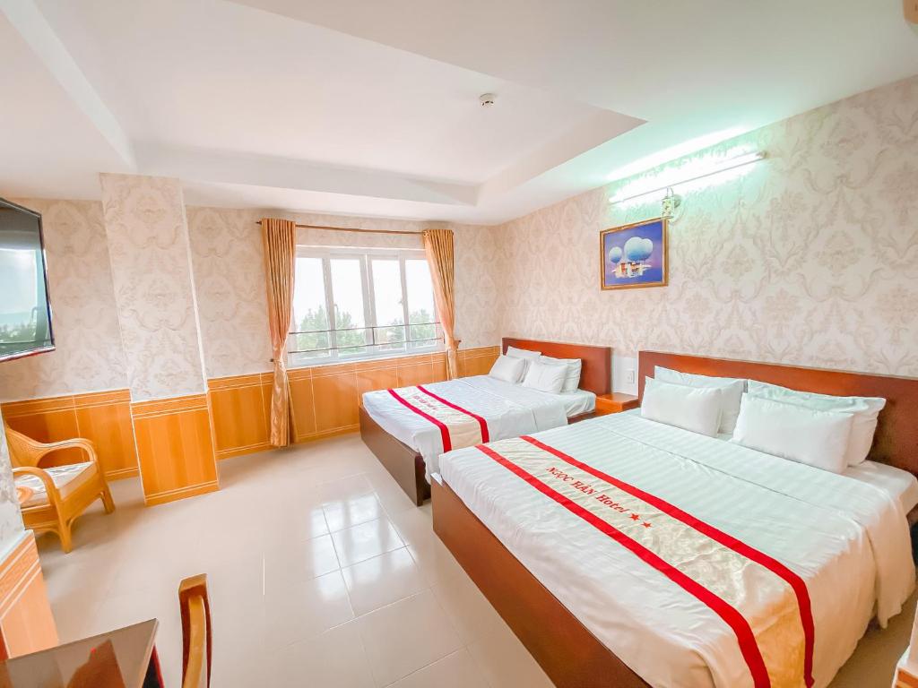 Postel nebo postele na pokoji v ubytování Ngọc Hân Hotel By The Moment