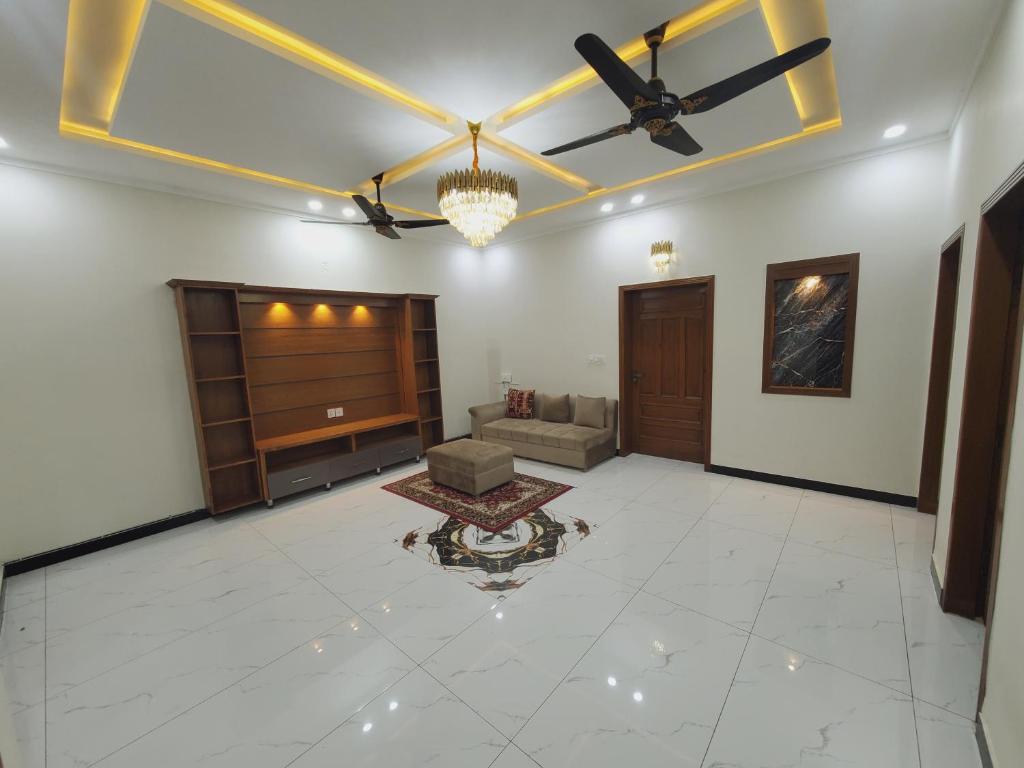 a living room with a ceiling fan and a couch at Kashees Lodges in Islamabad