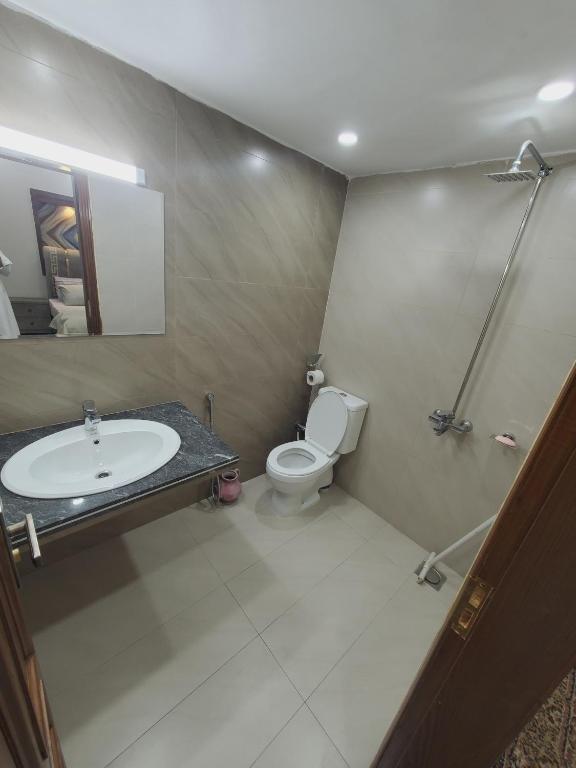 a bathroom with a sink and a toilet and a shower at Kashees Lodges in Islamabad