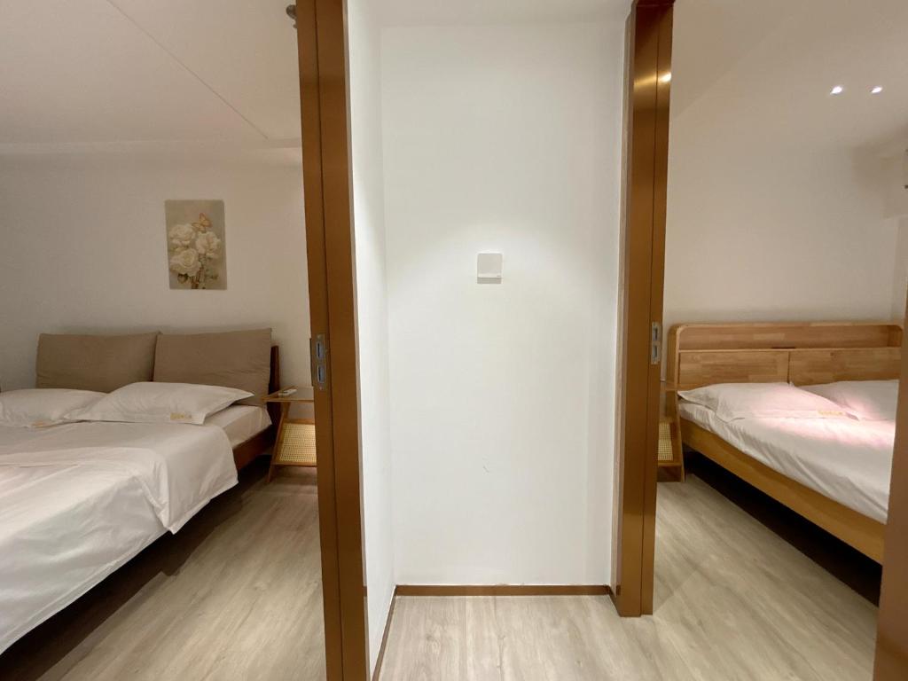 Postel nebo postele na pokoji v ubytování Zhongshan Perth Hotel Apartment - Shiqi Wanxianghui Branch