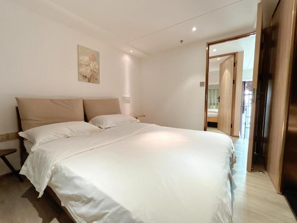 Postel nebo postele na pokoji v ubytování Zhongshan Perth Hotel Apartment - Shiqi Wanxianghui Branch