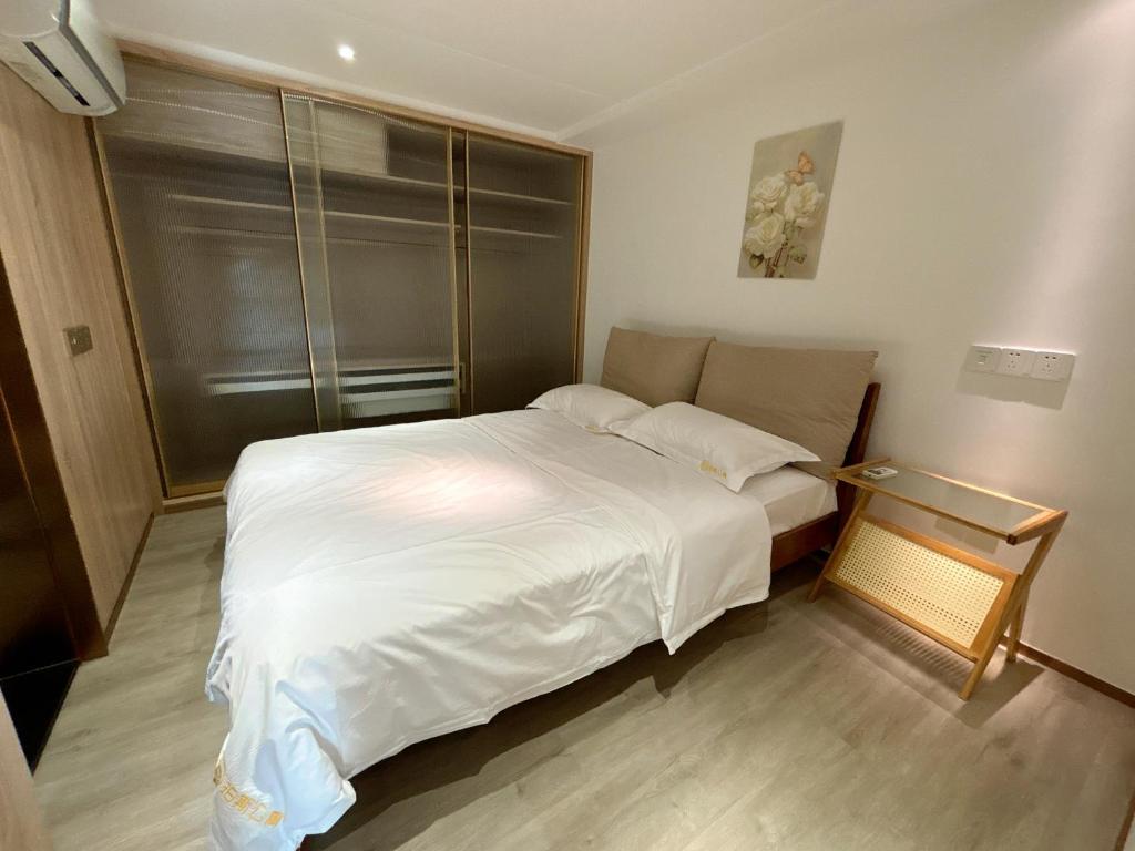 Postel nebo postele na pokoji v ubytování Zhongshan Perth Hotel Apartment - Shiqi Wanxianghui Branch