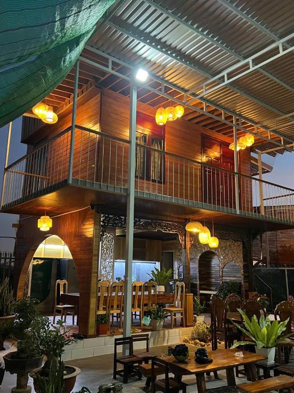 a building with a balcony with tables and chairs at Moc's Homestay-Phan Thiết in Ấp Tân Bình (2)