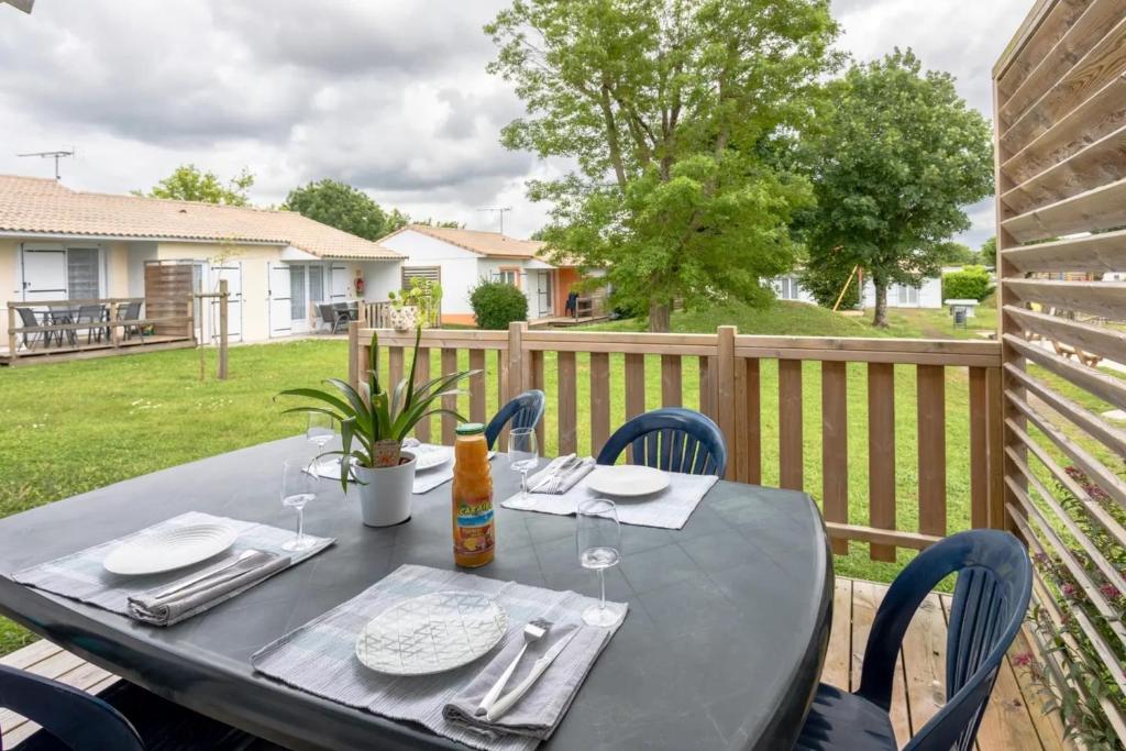 - une table avec des verres et des serviettes sur une terrasse dans l'établissement 2 - Le Martin-Pêcheur - Village vacances, à Maché