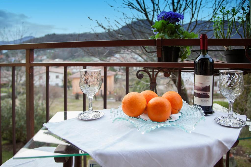 einen Tisch mit einem Teller Orangen und einer Flasche Wein in der Unterkunft B&B Marienn in Gavardo