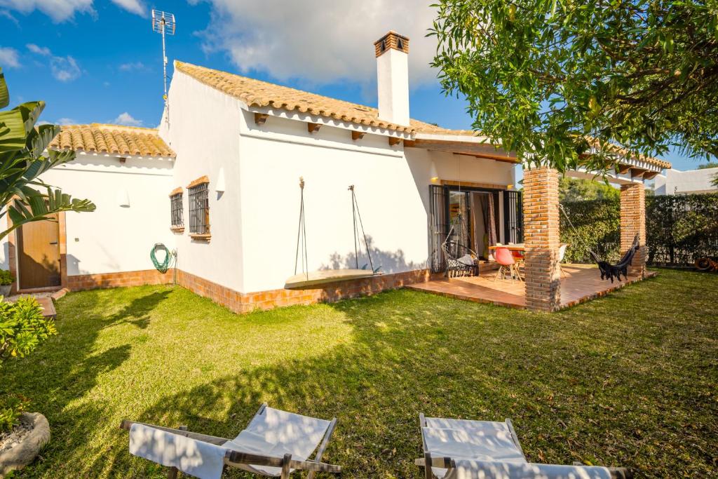 een uitzicht op de achtertuin van een huis met twee stoelen bij Casa ZAHOMAR con piscina exterior in Zahora