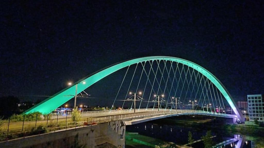 un pont vert sur une rivière la nuit dans l'établissement Strasbourg centre en 15 minutes, à Strasbourg