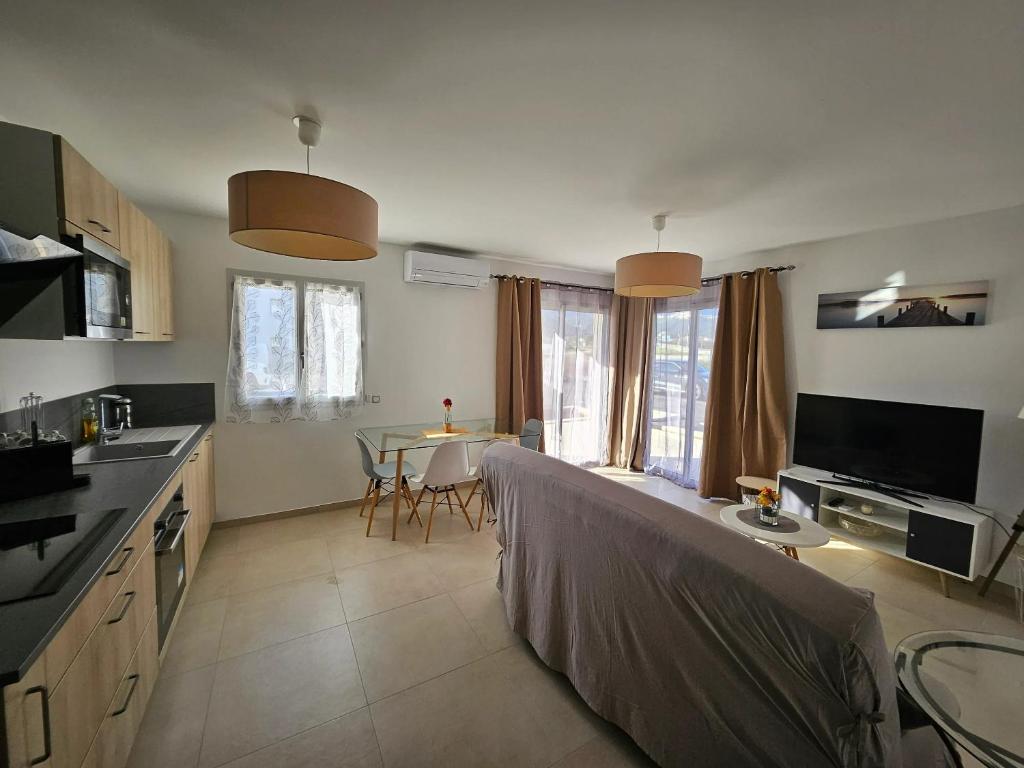- une cuisine avec un canapé et une table dans l'établissement Appartement cosy à Lucciana, 56 m², vue montagne, à Lucciana
