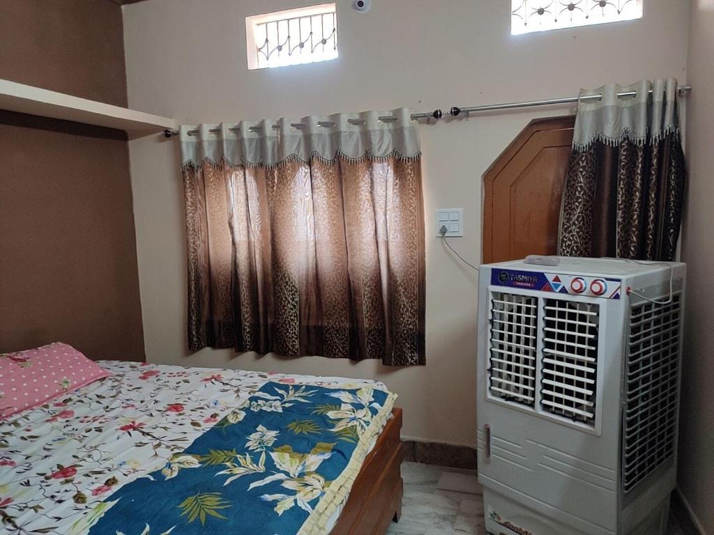 a bedroom with a bed and a window with curtains at Tirth HomeStay in Ujjain