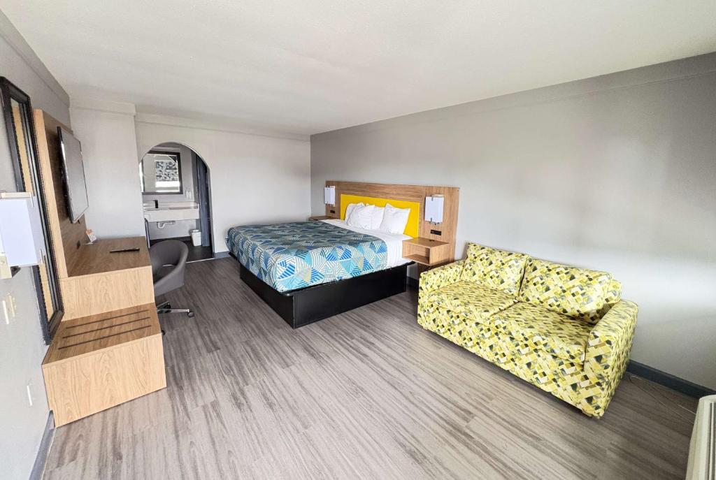 a hotel room with a bed and a couch at Days Inn by Wyndham Gonzales in Gonzales