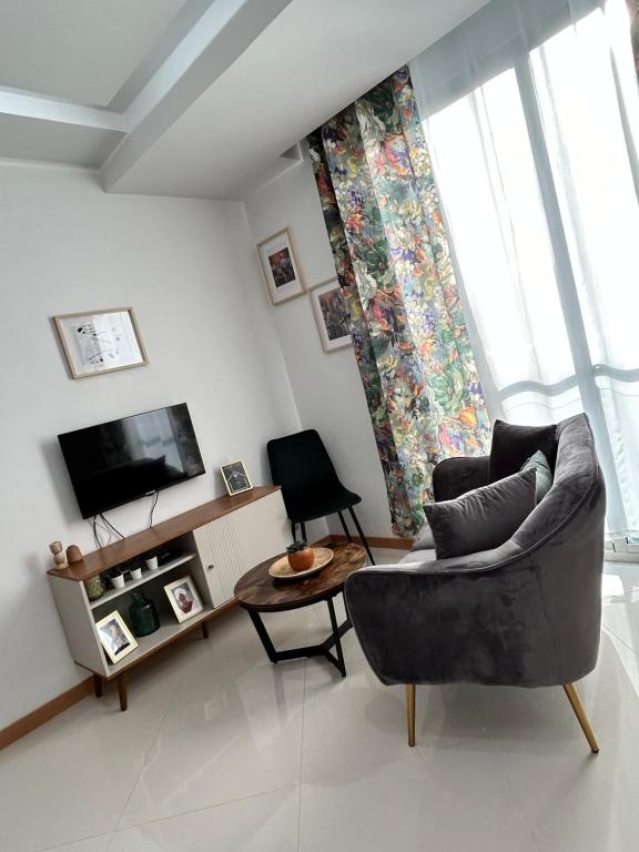 a living room with a couch and a tv at Apartamento Batuku in Praia