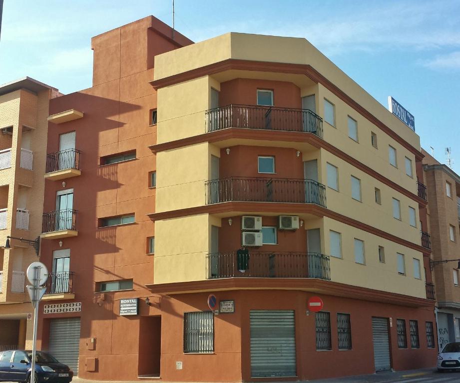 - un bâtiment avec des balcons sur le côté dans l'établissement Hostal Miguel y Juani, à L'Alcúdia