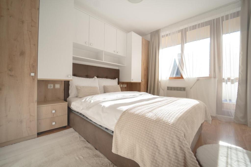 una camera da letto con un letto grande e una finestra di Pirin Sense Ap - SPA - FREE Parking a Bansko