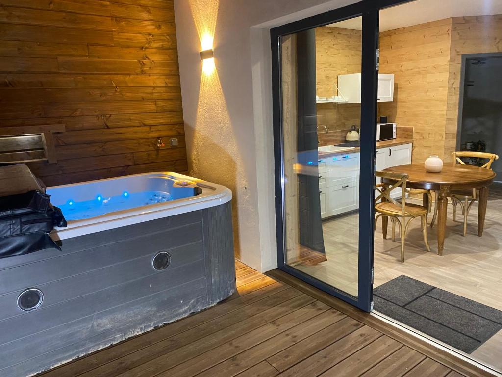 a jacuzzi tub in a room with a table at Chalet Lilas & Jaccuzi privatif in Rochesson