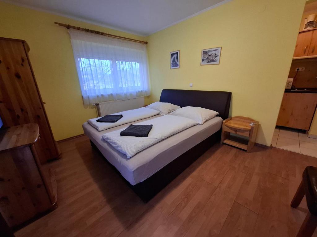A bed or beds in a room at Ilona Apartmanház
